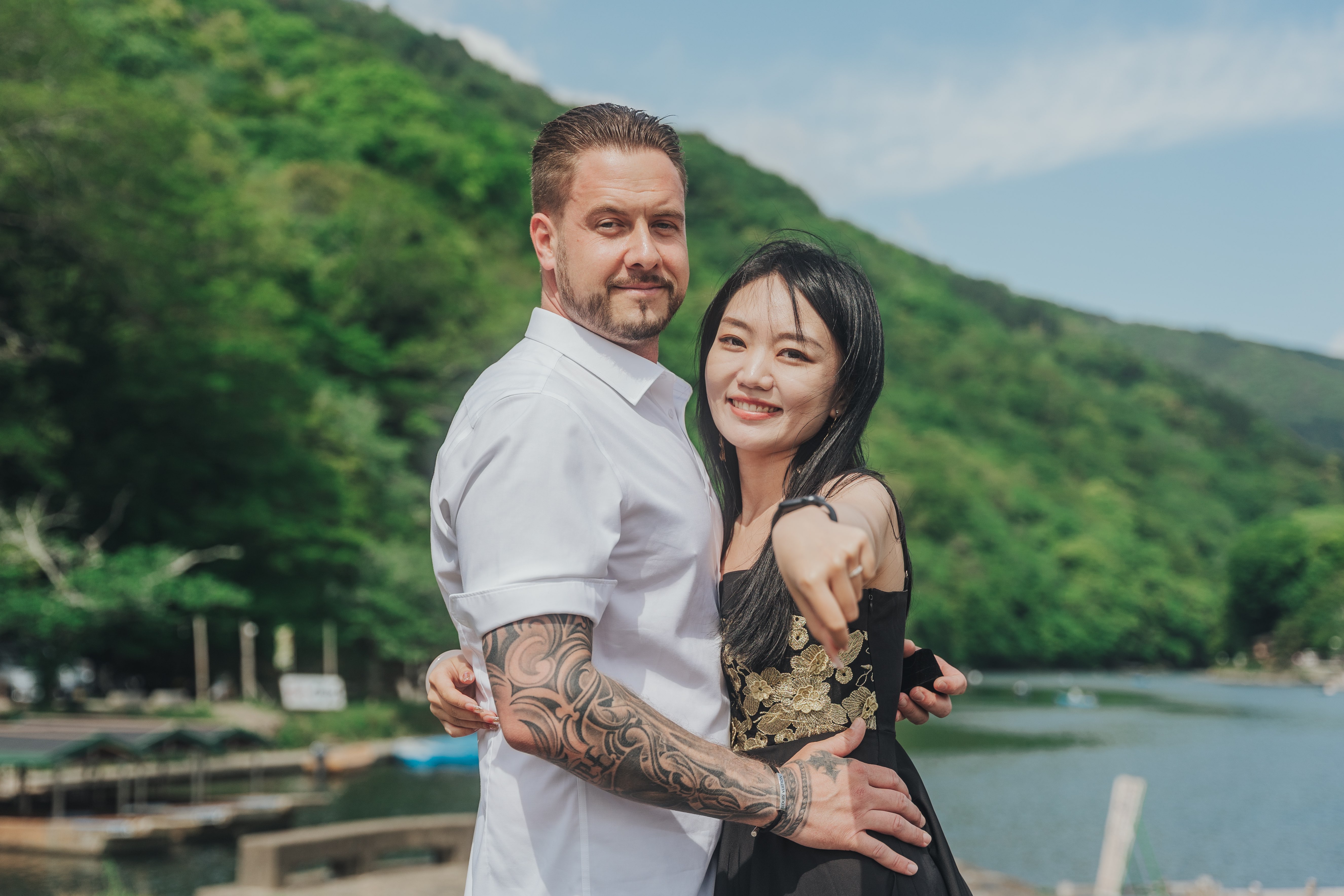 Romantic couple portrait by beautiful lake with green hills - nature photography